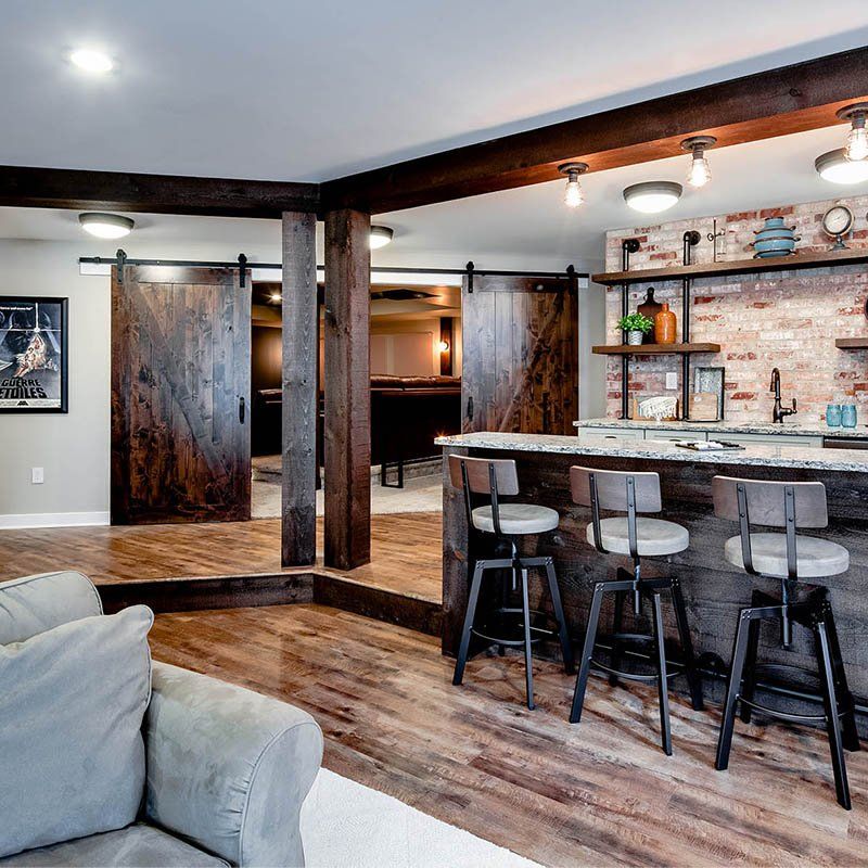 A living room with a couch and a bar with stools