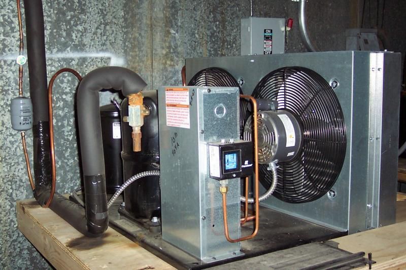 A fan with a warning label on it is sitting on a wooden shelf