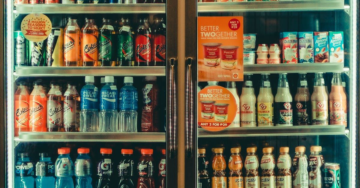 A refrigerator filled with bottles and cans of soda.