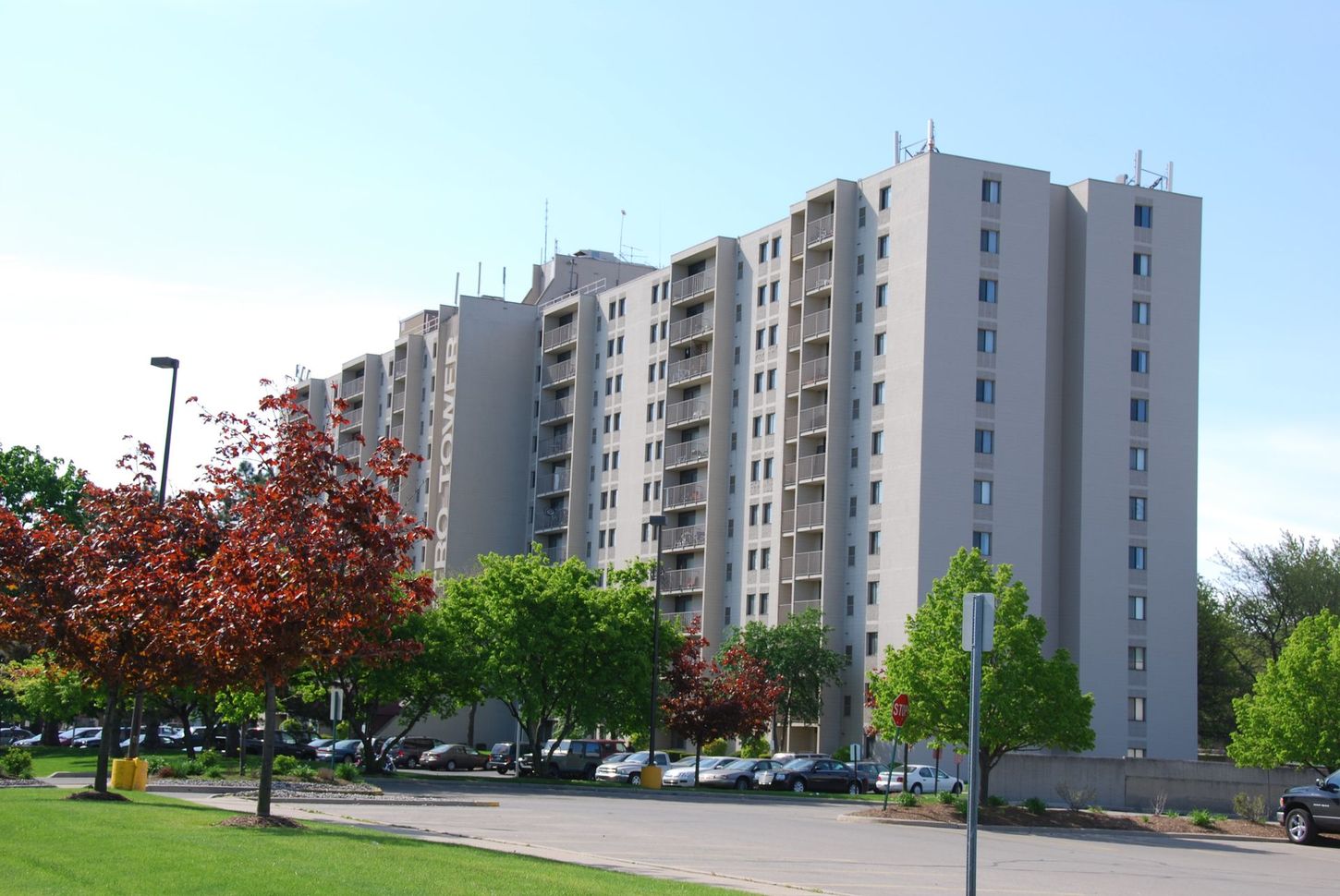 A tall building with a parking lot in front of it