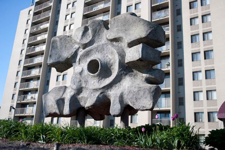 A large sculpture in front of a tall building