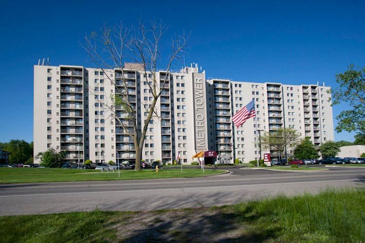 A large apartment building with an american flag flying in front of it.