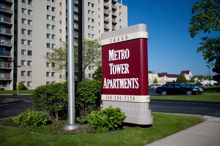 A red and white sign for metro tower apartments