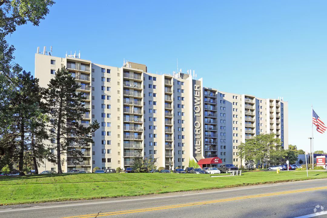 A large apartment building is sitting next to a road.