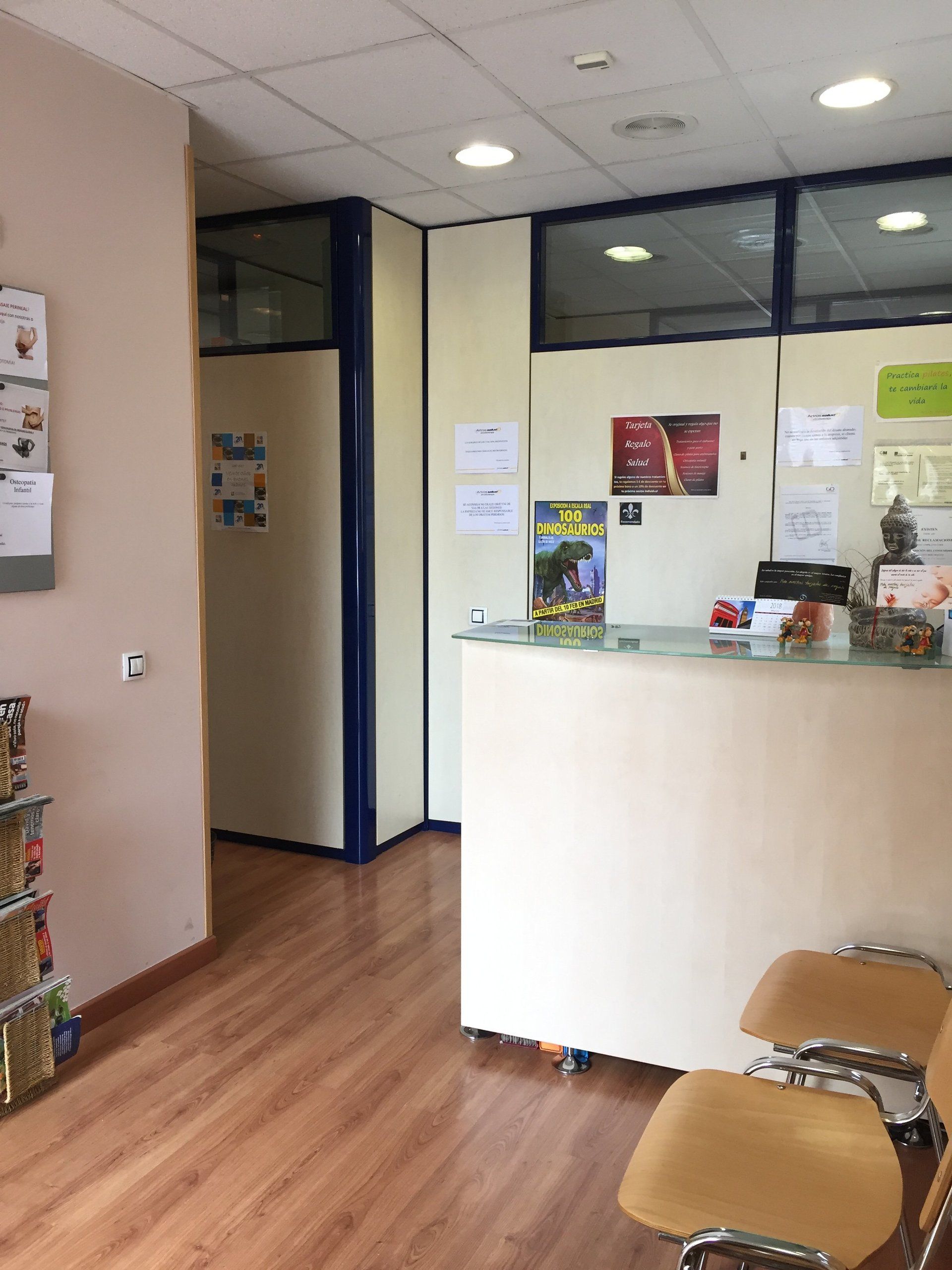 Una sala de espera con un mostrador blanco y sillas.