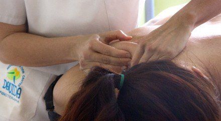 Una mujer está recibiendo un masaje de un masajista.