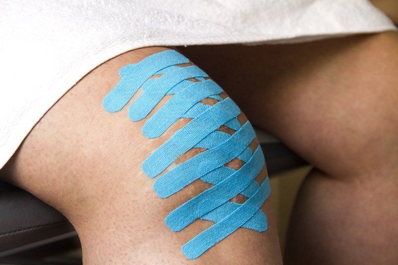 Una persona tiene cinta kinesiológica azul en la rodilla.