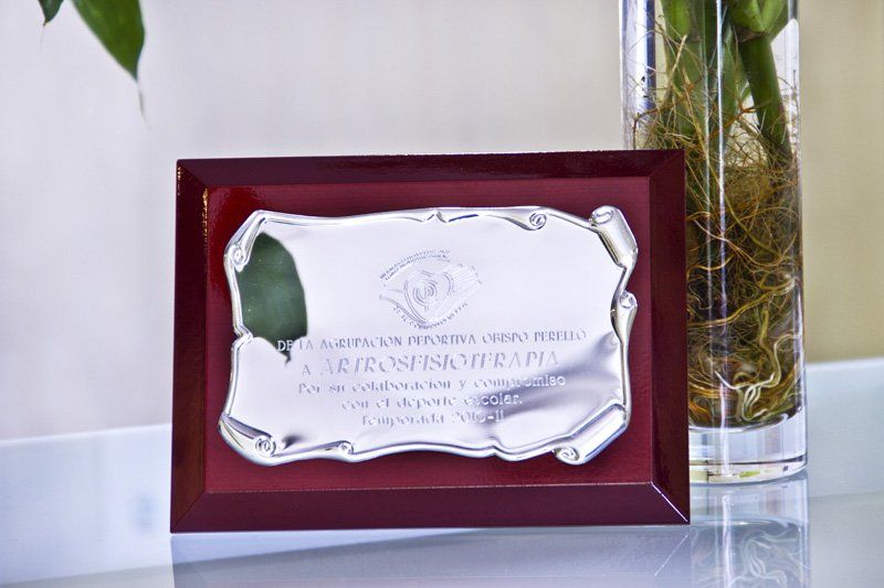 Una placa con una planta en un jarrón al lado.