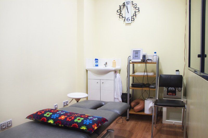 Hay un reloj en la pared encima de la cama en la habitación.