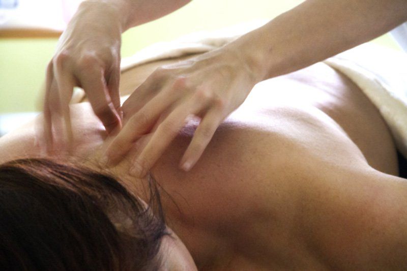 Una mujer está recibiendo un tratamiento de acupuntura en la espalda.