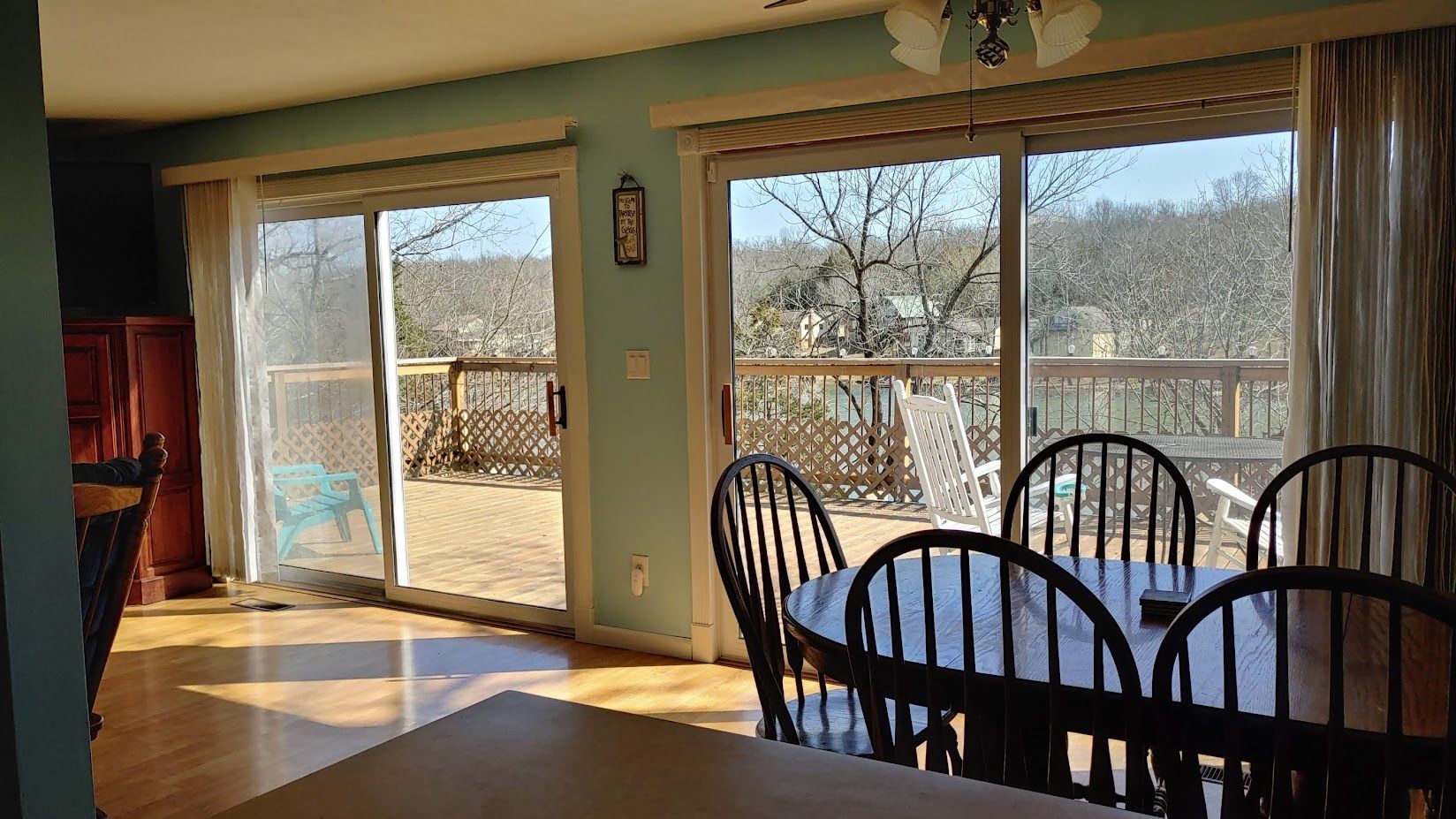 A dining room with a table and chairs and sliding glass doors leading to a deck.