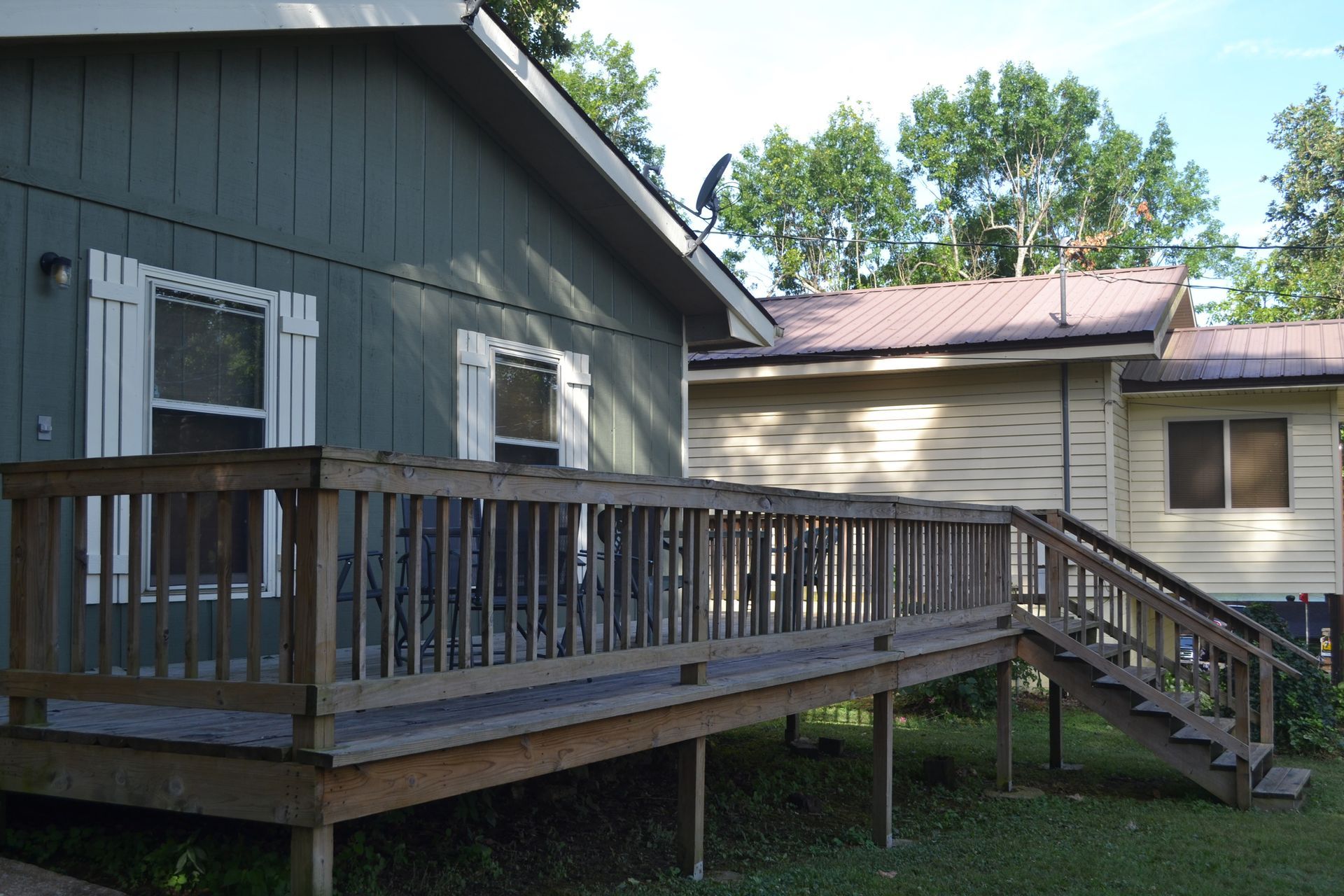 A house with a wooden deck and stairs leading up to it