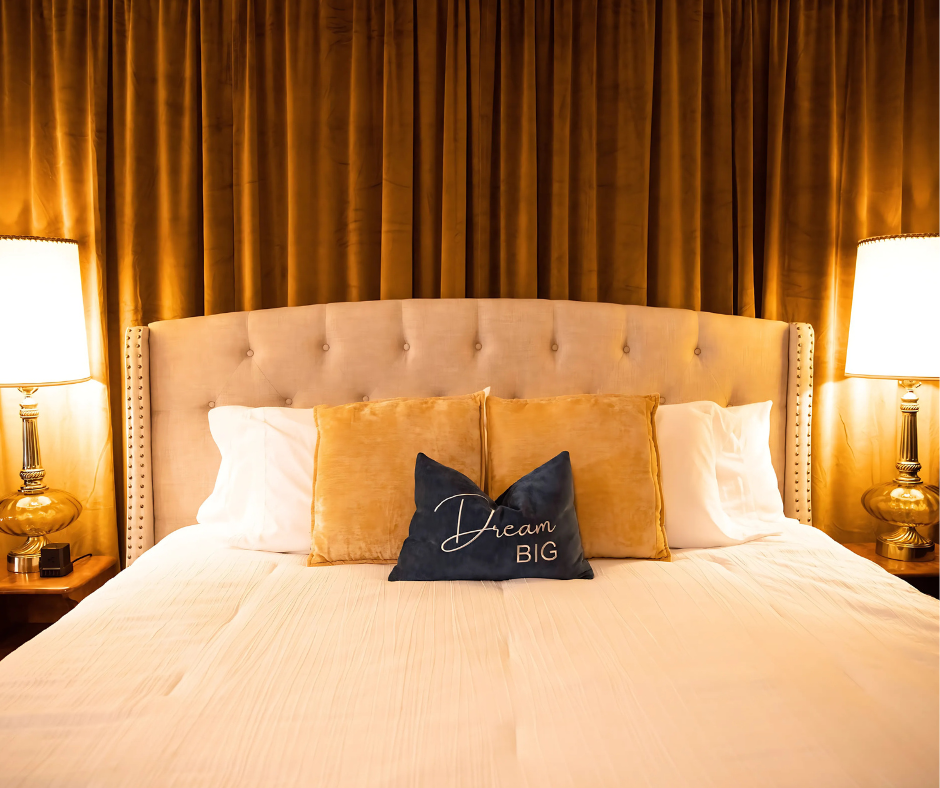 A bed with a headboard and two lamps in a hotel room.