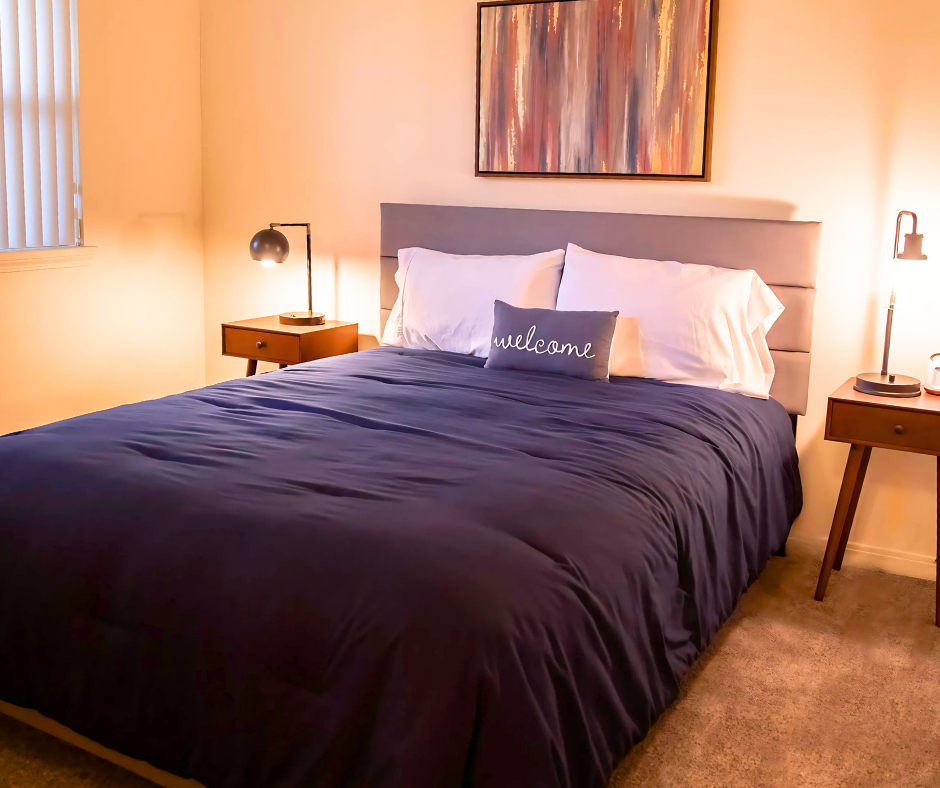 A bedroom with a king size bed and a ceiling fan.