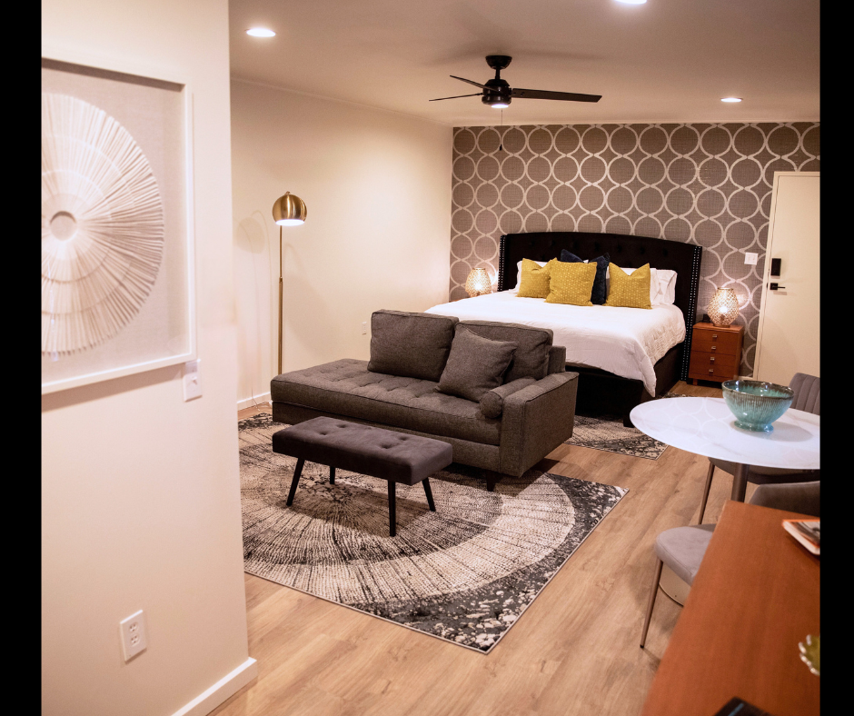 A hotel room with a bed , couch , table and chairs.