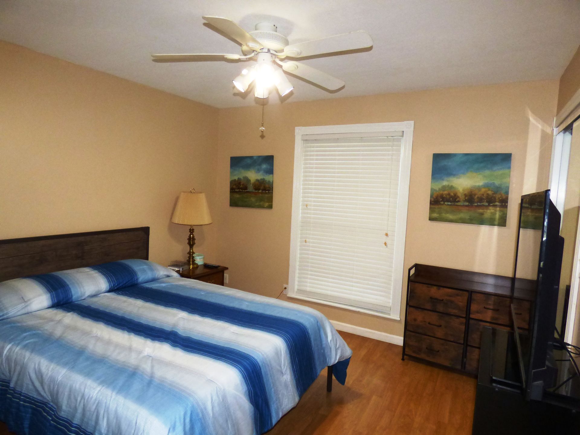 A bedroom with a bed and a ceiling fan