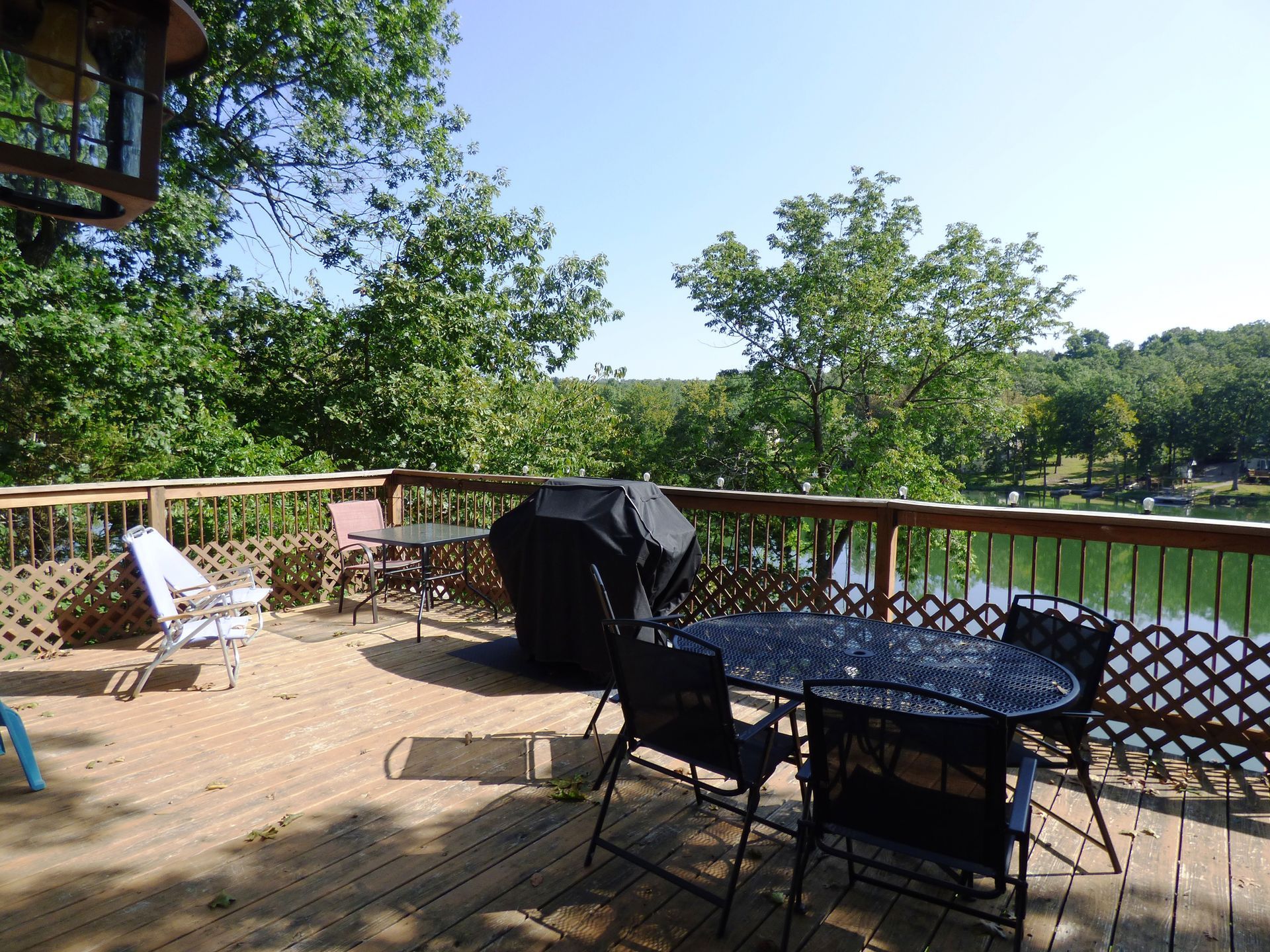 A deck with a table and chairs overlooking a lake