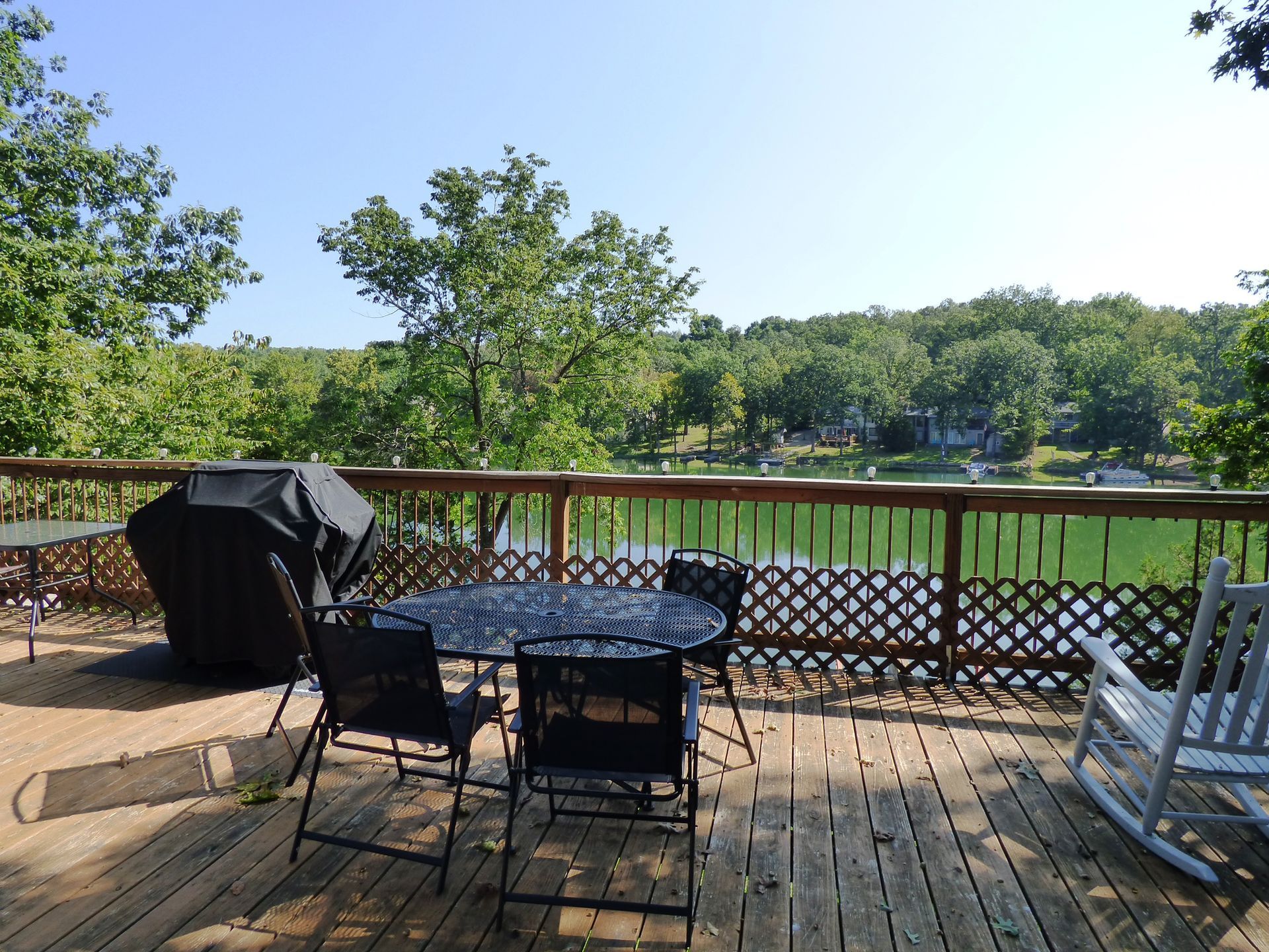 A deck with a table and chairs overlooking a lake