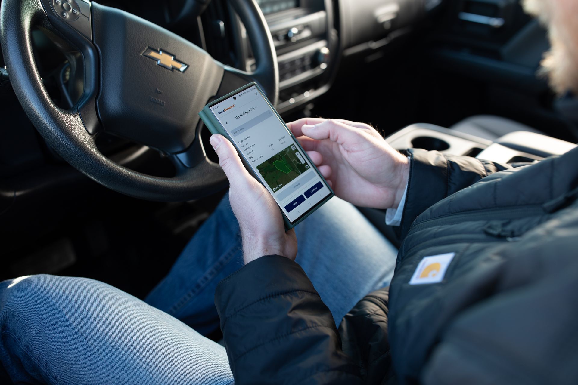 Drone operator looking at AcreConnect software on his phone