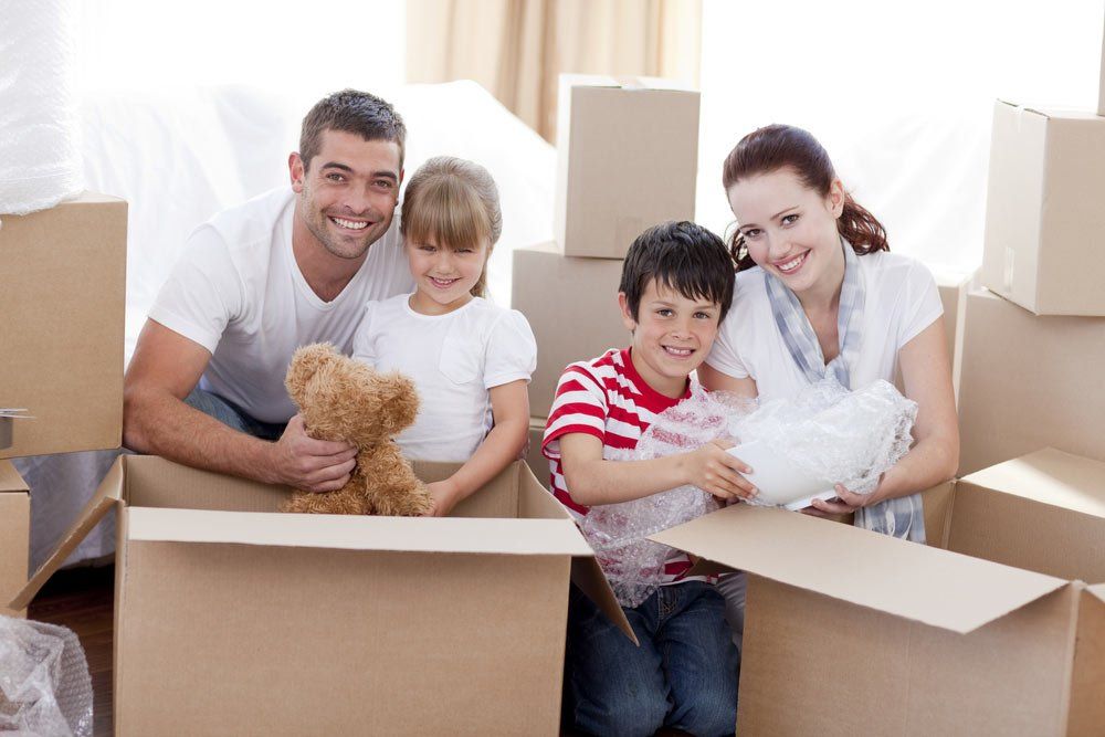 Happy Family Surrounded By Moving Boxes — Mortgage Brokers In Mundingburra, QLD
