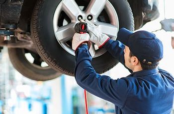 Car Care — Mechanic Installing The Tire in Plymouth, MN