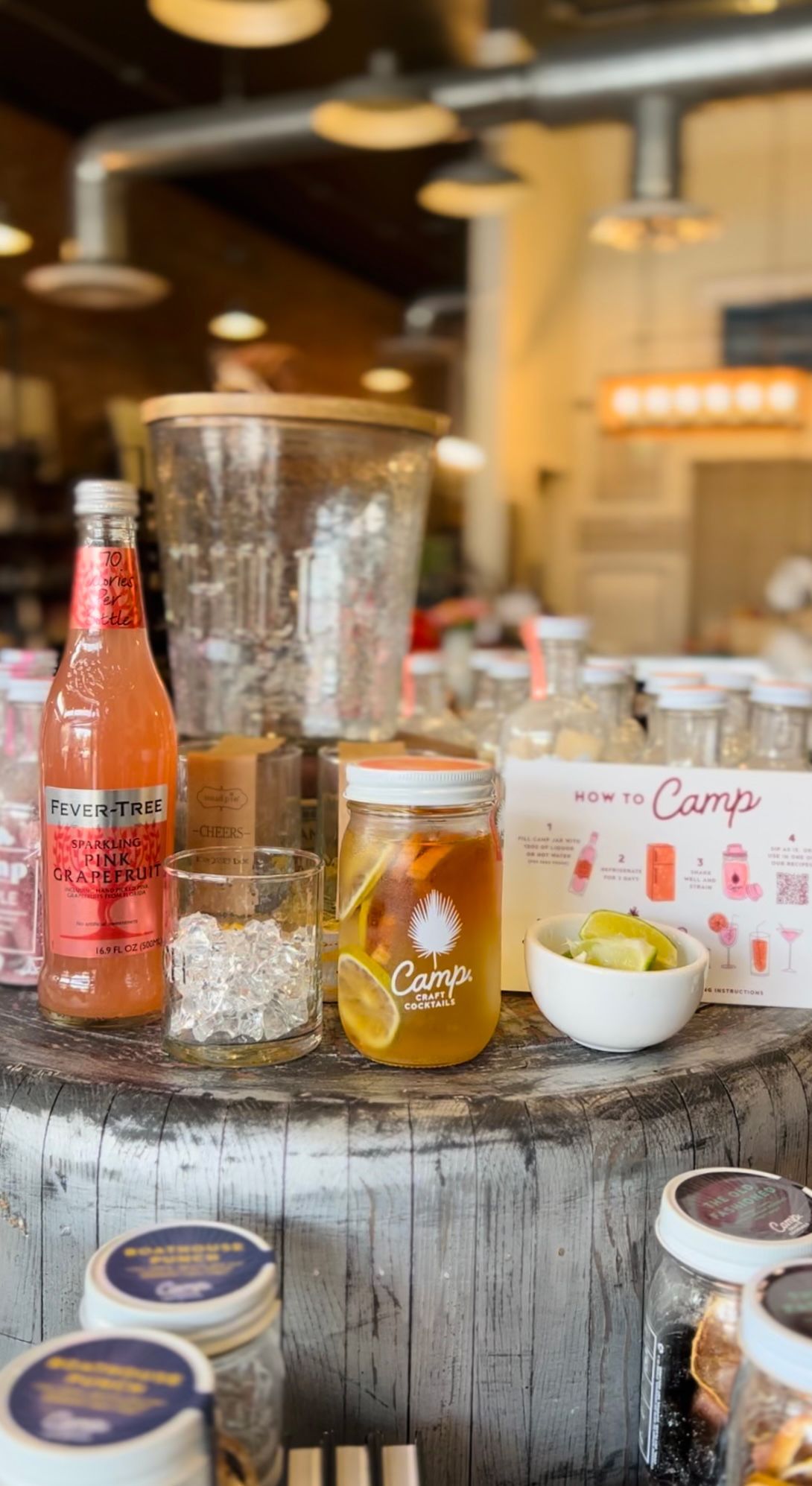 a blender is sitting on top of a wooden table next to a bottle of soda .