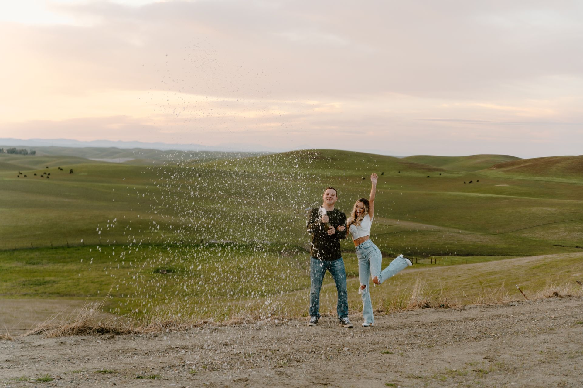 a man and a woman are throwing confetti in the air in a field .