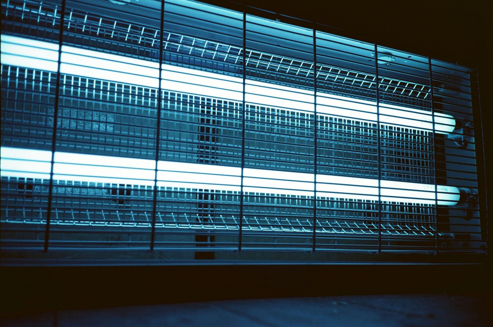 A mosquito killer is lit up in a dark room