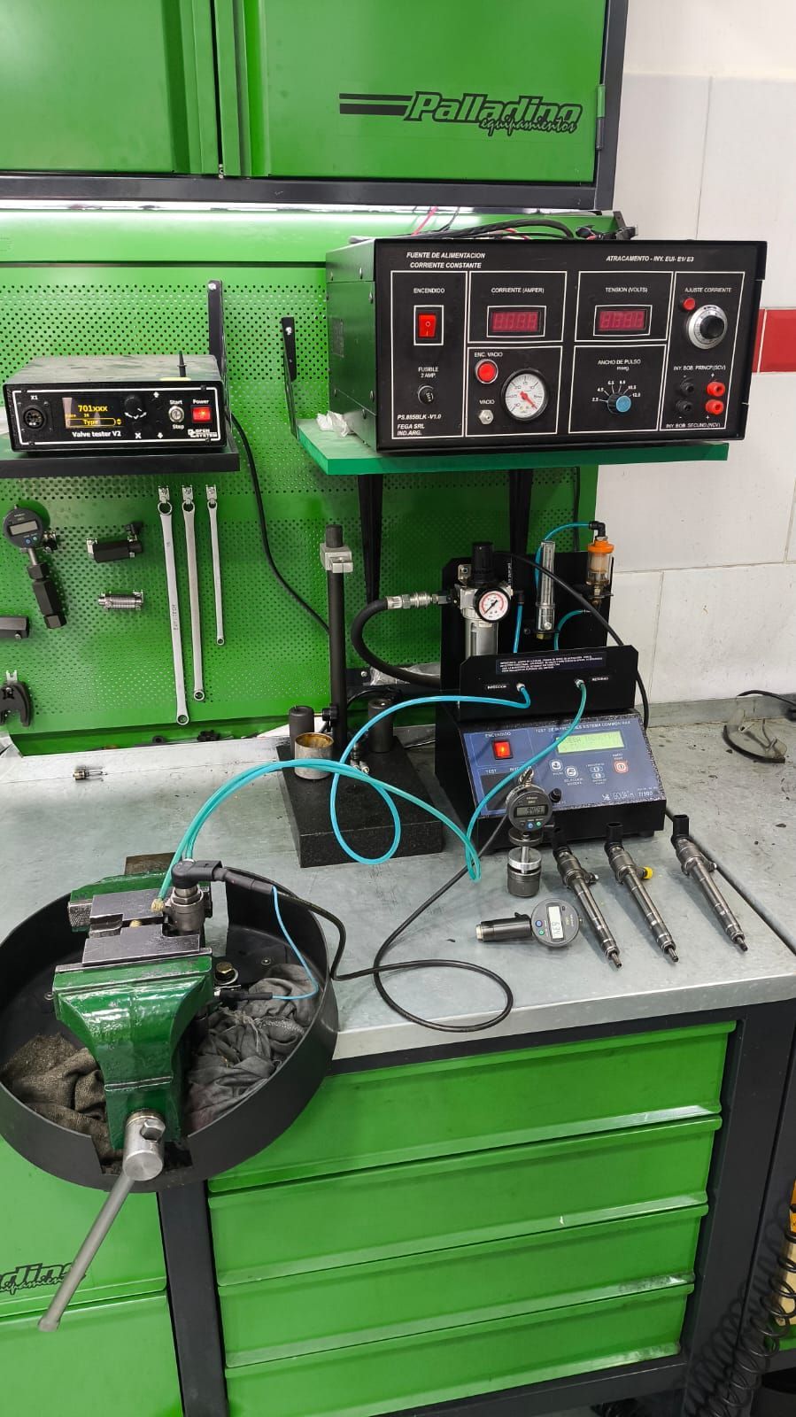 Equipo de prueba de inyectores diesel en un taller, colores verde y negro.