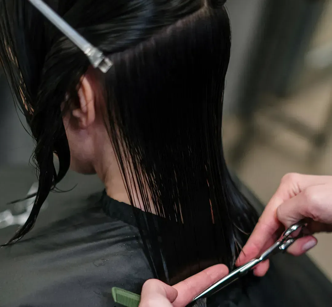 Une femme se fait couper les cheveux par un coiffeur