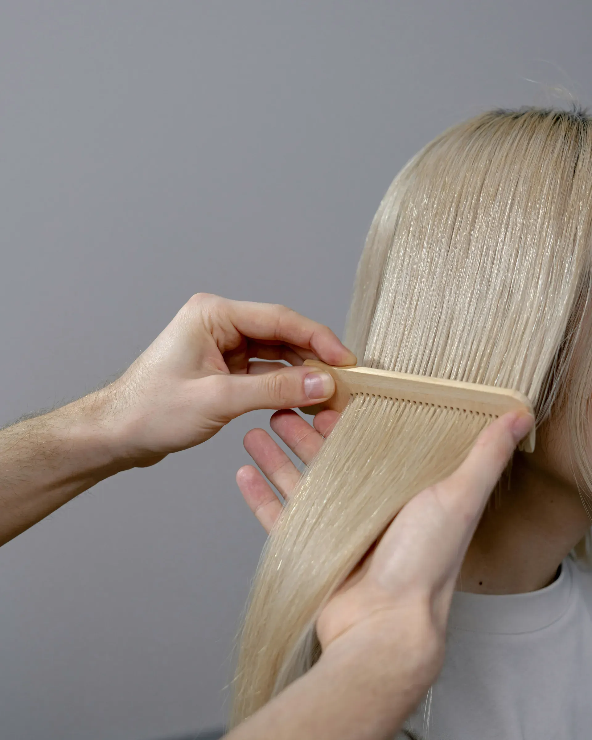 Une femme se fait peigner les cheveux par un homme.