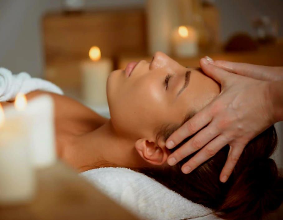 Une femme aux longs cheveux blonds porte un pull blanc.