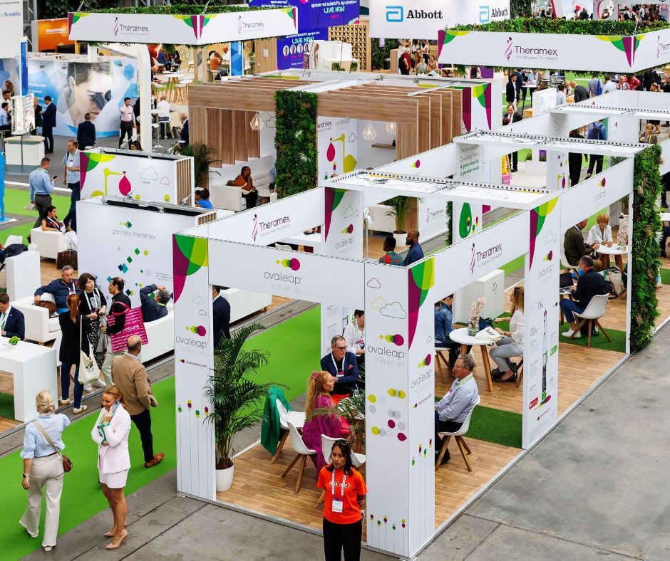Trade show with booths, people, bright colors, and plant accents.