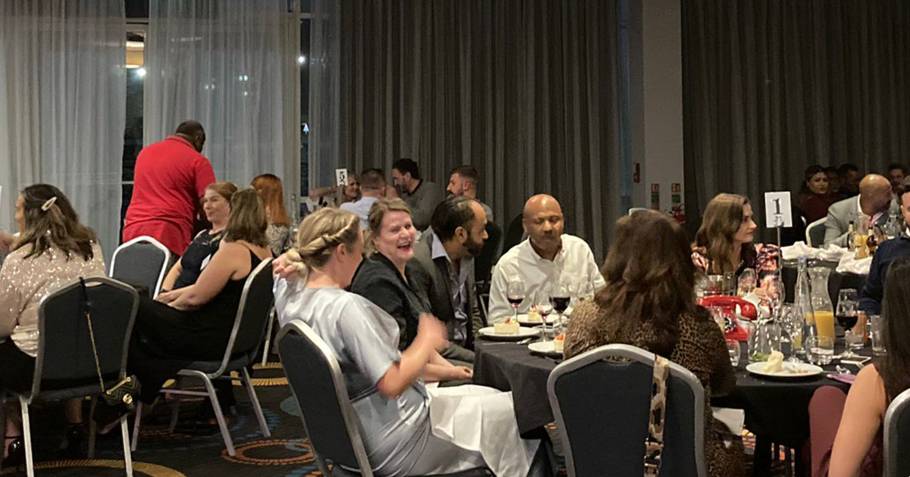 A group of people are sitting at tables in a room.