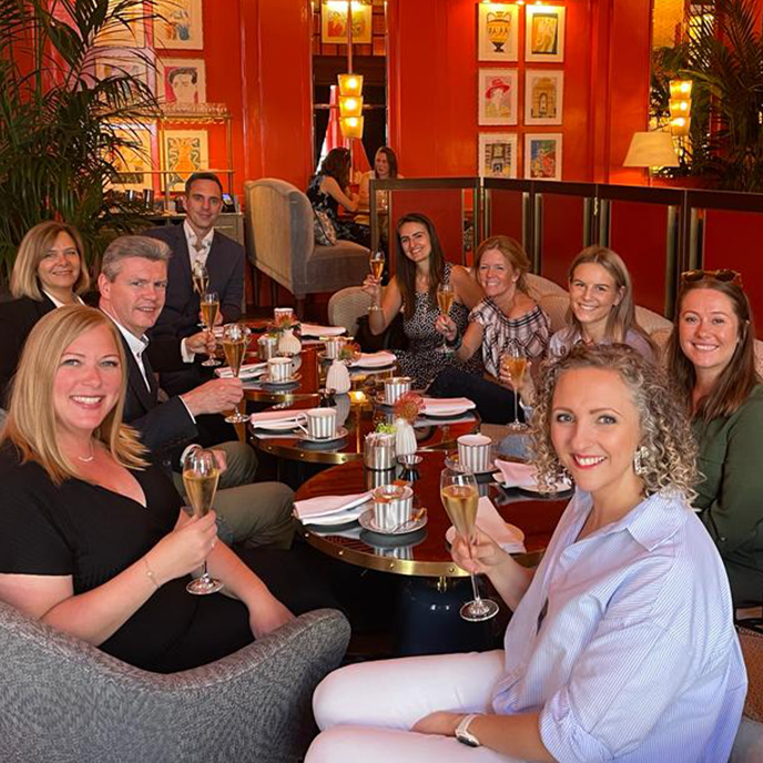 A group of people are sitting around a table drinking champagne