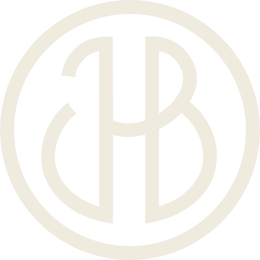 Kermanvärinen logo, jonka sisällä on kirjaimet