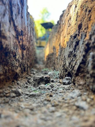 A close up of a trench filled with dirt and rocks.