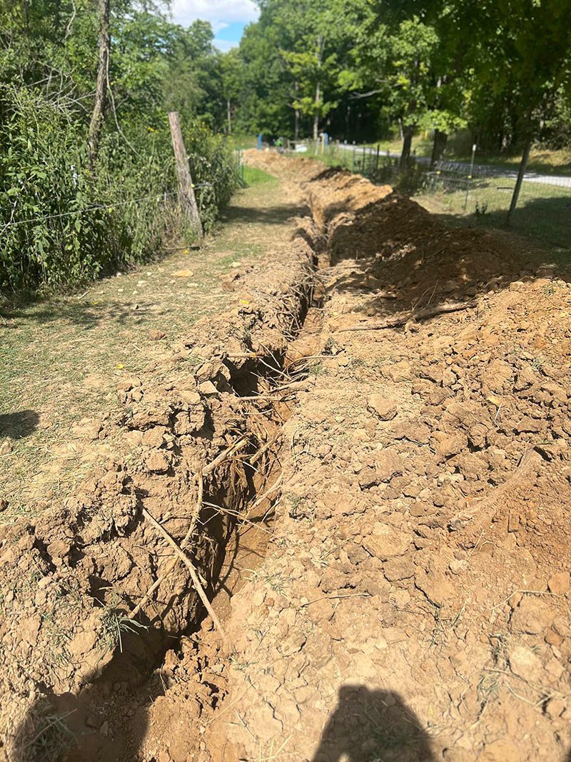 A large pile of dirt is sitting in the middle of a field.