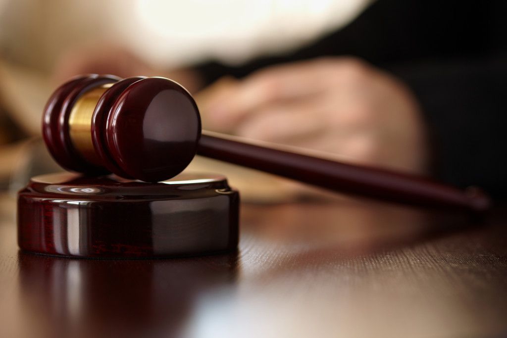 A wooden judge 's gavel is sitting on a wooden table.