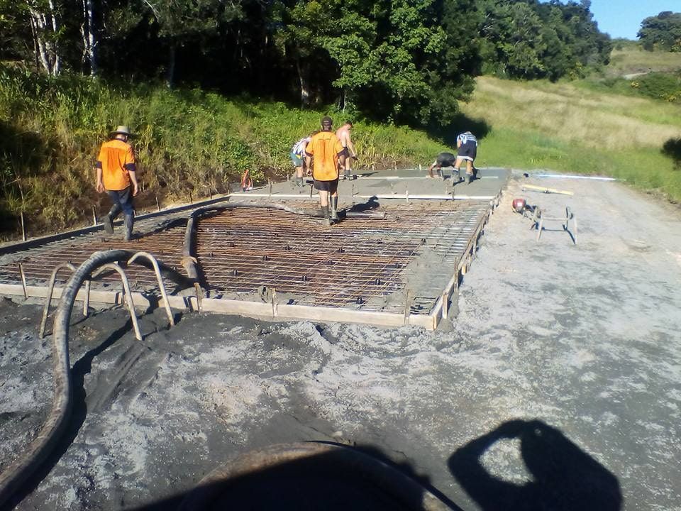Construction Workers Pouring Concrete on a Rebar — Coota & Son's Concrete Pumping In Ballina, NSW