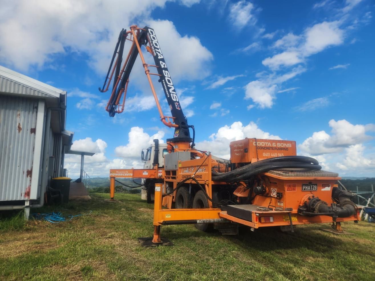 Orange Concrete Pump Truck With Boom Extended — Coota & Son's Concrete Pumping In South Gundurimba, NSW
