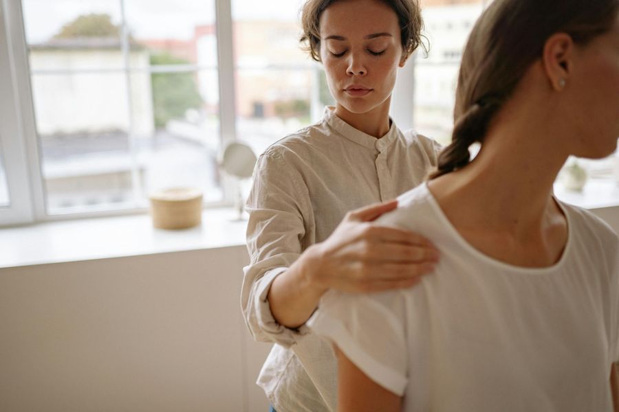 A woman is giving a massage to another woman.