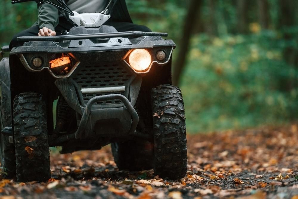 A Person Is Riding An Atv On A Dirt Road In The Woods — JBS Mobile In Lennox Head, NSW