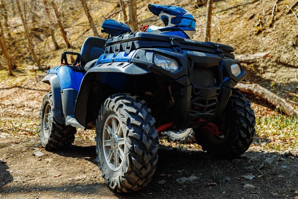 A Blue Atv Is Parked On A Dirt Road In The Woods — JBS Mobile In Byron Bay, NSW