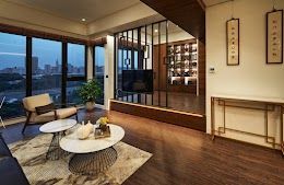 現代客廳，配有大窗戶、木地板、矮桌，可欣賞城市天際線景觀。