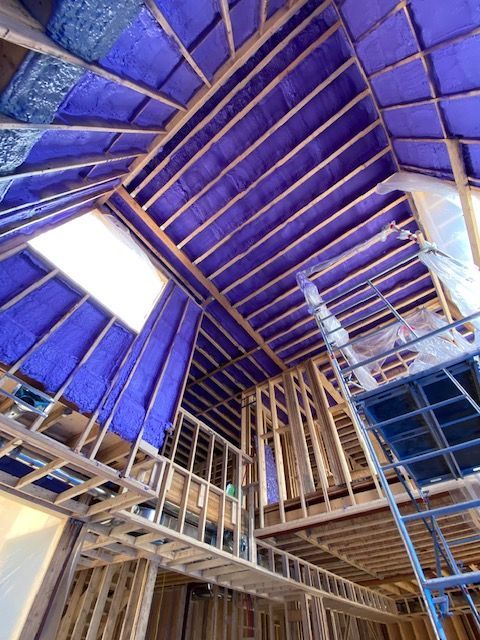 A building under construction with purple insulation on the ceiling.