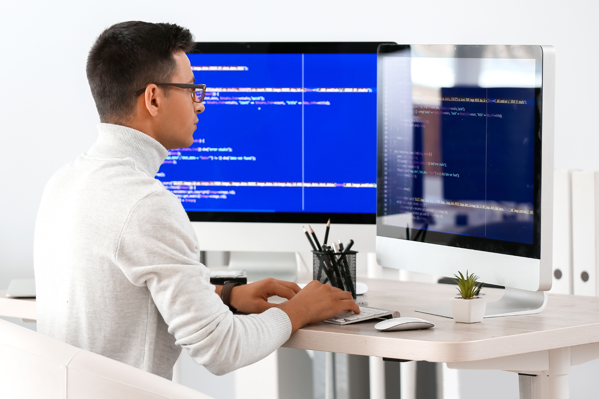 Un hombre está sentado en un escritorio trabajando en una computadora.