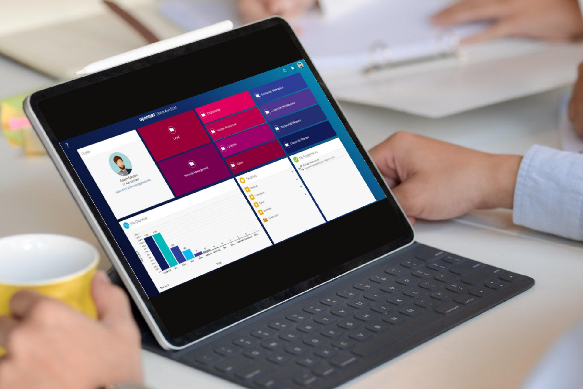 Una persona sostiene una taza de café mientras usa una tableta.