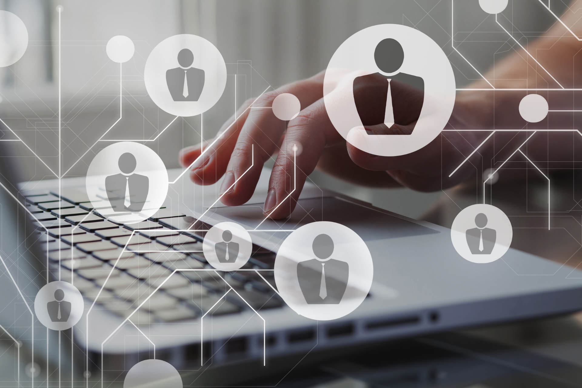 Una persona está escribiendo en una computadora portátil con íconos de personas en la pantalla.