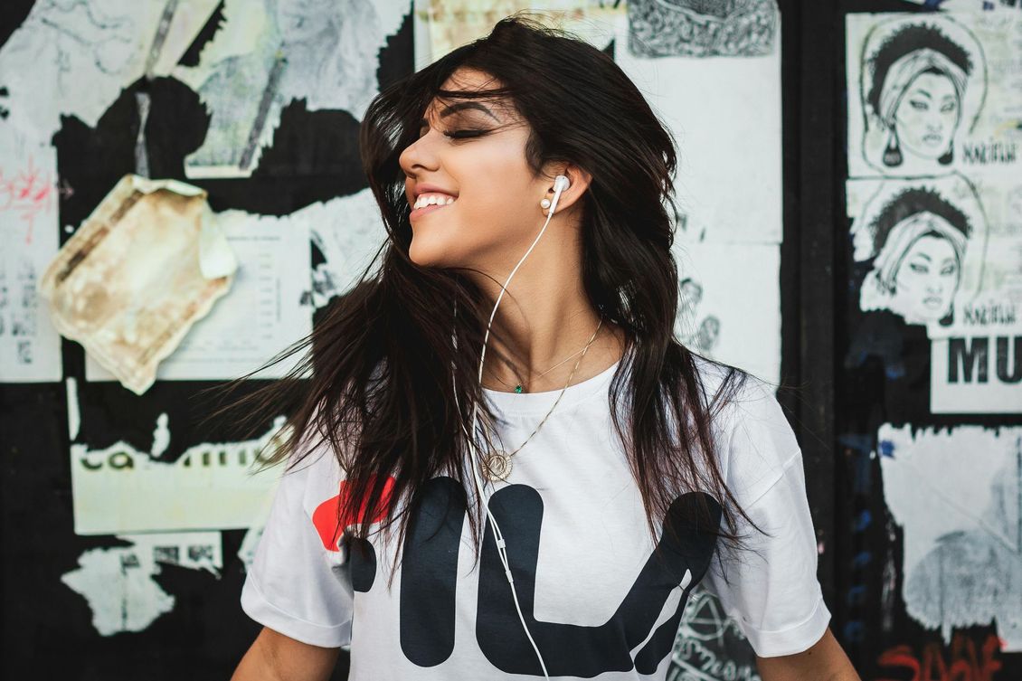Uma mulher vestindo uma camisa fila está ouvindo música